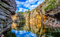 Reflection of water in a river canyon among the mountains. Cliffs are reflected in the water. Reflection in water scene