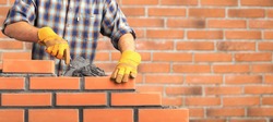 Bricklayer industrial worker installing brick masonry