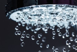 Shower Head with Water Stream on Black Background