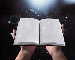 Man opened a magic book with growing lights and magic powder. Learning and education concept.