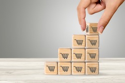 Sale volume increase to make a business grow,  wooden cube with shopping cart symbol.