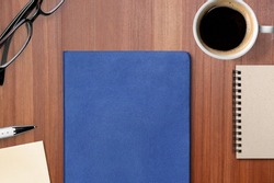 Concept of employee handbook over wooden office table.