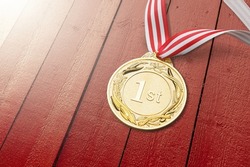 An Olympic Winter Games gold medal on a red background.