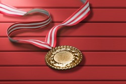 Gold medal of the Olympic Winter Games on a wood background.