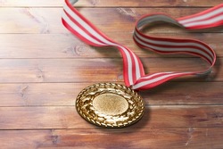 Gold medal of the Olympic Winter Games on a wood background.