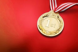 An Olympic Winter Games gold medal on a red background.