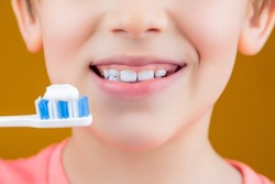 Dental hygiene. Happy little kid brushing her teeth. Kid boy brushing teeth. Boy toothbrush white toothpaste. Health care, dental hygiene. Joyful child shows toothbrushes. Little boy cleaning teeth.