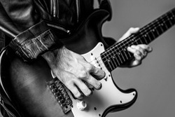 Electric guitar. Repetition of rock music band. Music festival. Black and white.