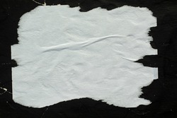 White crumpled paper pasted on a black wall.
