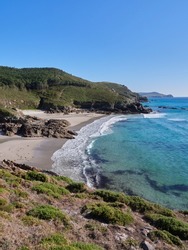 Costa da Morte beach on the Atlantic Ocean on a summer day with calm sea. This region of northern Spain is known for its unspoiled coastline and surfing waves.