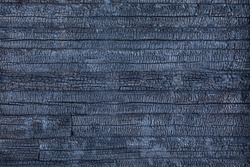 Black macro or closeup background, backdrop or texture of wood wall of old building, house or edifice after wildfire