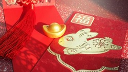 Chinese Lunar New Year red envelope with rabbit and blessing word contained money as a gift on red background with ancient gold bullion nugget. The Chinese word means ‘happiness and good fortune’.
