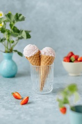 Vegan strawberry ice cream in the horn in a glass on a gray background. healthy vegan dessert. High quality photo
