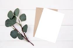 Blank paper sheet copy space with mockup and leaf on wooden table, card, poster and envelope, postcard decoration your design or branding, simplicity and minimal, nobody, flat lay, top view.