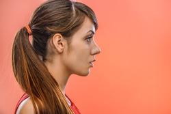 young beautiful dark-haired calm woman in profile, on red background