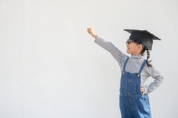 children girl wearing a graduate cap over white background very happy and excited doing winner gesture with arms raised, smiling and screaming for success. Celebration concept.