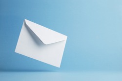 Envelope falling on the ground, blue background with negative space