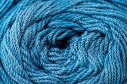 Macro texture of woolen blue thread, close-up, copy space. Macro Photography of a coil with threads. Sewing background, screensaver. Abstraction, interweaving of natural threads