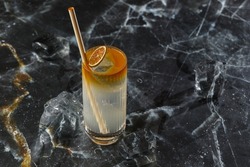 Dark n Stormy cocktail standing on the black marble background. Refreshing Boozy Rum Dark and Stormy Cocktail with Ginger Beer