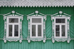 Richly decorated ornamental carved windows, frames on vintage wooden rural house in Suzdal town, Vladimir region, Russia. Russian traditional national folk style in wooden architecture. Countryside