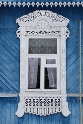 Ornamental window with carved frame on vintage wooden rural house in Dunilovo village in Ivanovo region, Russia. Building facade. Russian traditional national folk style in architecture. Countryside