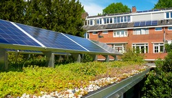 Solar panels on a green rooftop with blooming sedum. Solar panels on a green rooftop with blooming sedum. Green solar rooftop garden for renewable sustainable energy. Green energy concept for sustaina