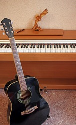 Guitar next to the piano