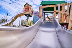  Colorful wooden playground with slide in a kindergarten park for play time outdoor                               