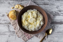 buttered grits with biscuits in rustic setting top view