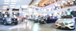 Blurred background of new cars displayed in luxury showroom with light bokeh in motor show event, panorama