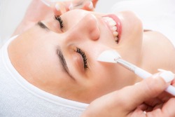 Face peeling at the beautician. Facial treatments. Photo chemical, glycolic, almond peeling.
