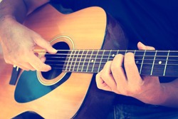 Details of performer man hands playing acoustic guitar musical, vintage retro photo