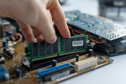 close up hand insert or install the ram memory component in the pc motherboard
