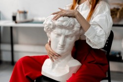 young stylish girl hug white sculpture. creative idea, art concept