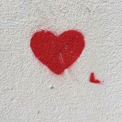 Anonymous drawing of red heart isolated on a wall in a French city.