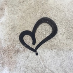 Anonymous drawing of an artistic black heart isolated on a wall in a French city.