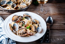 Traditional italian seafood pasta with clams Spaghetti alle Vongole on wooden background