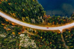 Aerial view of road and colorful autumn forest with blue lakes in Finland Lapland.
