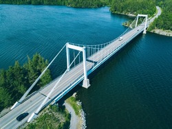 Aerial view of white cable-stayed bridge in Finland. Beautiful summer landscape with blue lakes, green woods and white suspension bridge