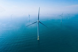 Wind turbine. Aerial view of wind turbines or windmills farm field in blue sea in Finland. Sustainable green clean energy.