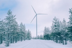 Aerial view Wind turbine in snow winter landscape in Finland, Europe. Alternative energy in winter.