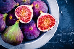 Fresh ripe figs in a bowl closeup on a dark background