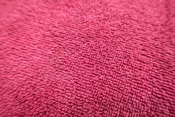 Selective soft focus of Red towel texture fabric background. Abstract pattern seamless of swimming pool or beach towel with absorbing water fur innovation or Shaggy fur bath, close up & top view.   