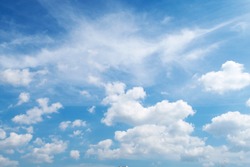 Natural sunny blue sky background with beautiful puffy white cumulus clouds & fluffy cirrus cloudscape on bright daylight horizon in tropical summer sunlight & exotic sun ray at sunny & sunshine day