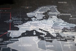 Close-up macro image of a map. Focused on central european countries. Dark grey blue map. Cloth texture.