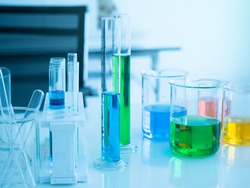 Glass tube, beaker, flask with colorful fluid in small science lab