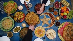 Ramadan iftar Eid. Muslim family has dinner at home. Table with traditional food. Eid al-Fitr celebrations