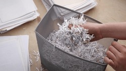 Shredded private confidential documents. Shredded paper in a shredder container