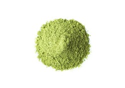 Heap of green superfood powder on white background. Matcha tea powder, spinach, chlorella, moringa, wheatgrass, or broccoli powder. View from above, free space for text or design.