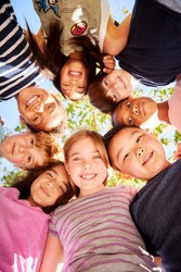 Group of kids outdoors looking down at camera,verticle